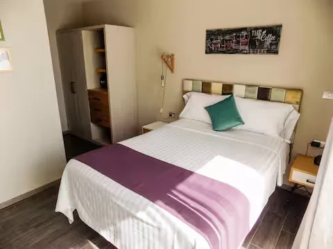 Recámara en apartamento boutique Suites 509, Pachuca: cama con cabecera de madera recuperada y ropa de cama blanca