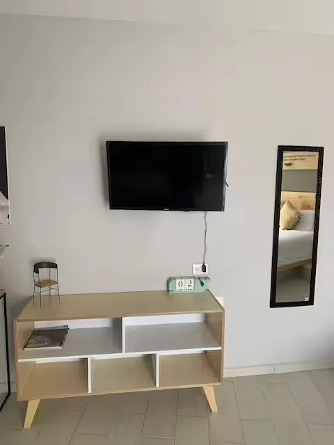 Área de TV en Suite Terraza Suites 509: pantalla HD montada en pared, consola de madera y espejo en loft Pachuca
