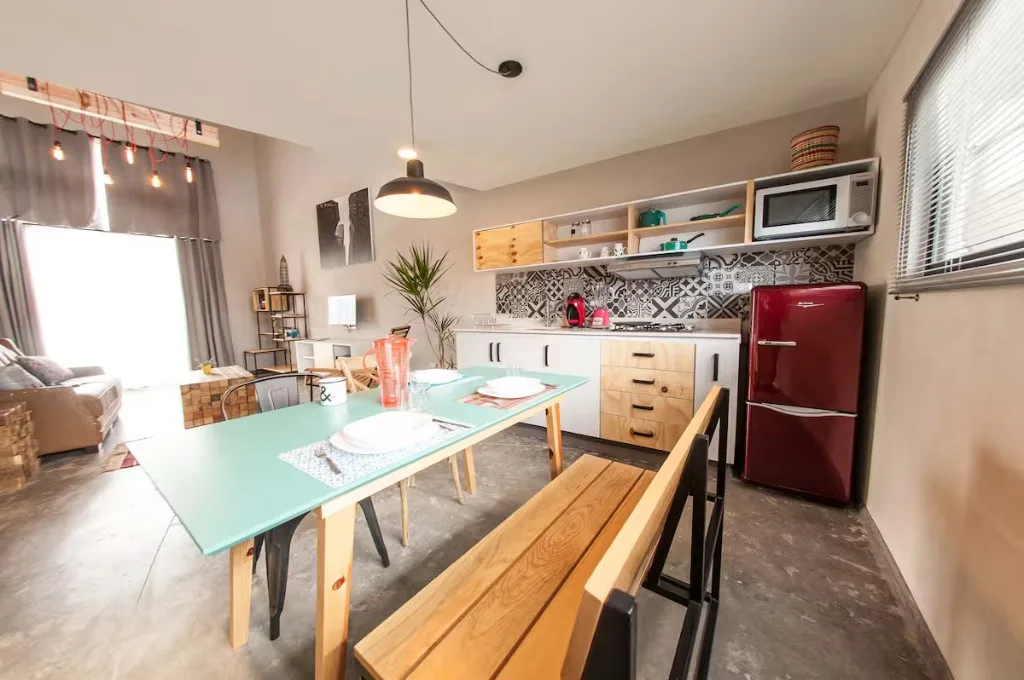 Cocina y comedor del Loft de diseño Suites 509, Pachuca: mesa turquesa, refrigerador retro rojo y backsplash de azulejos