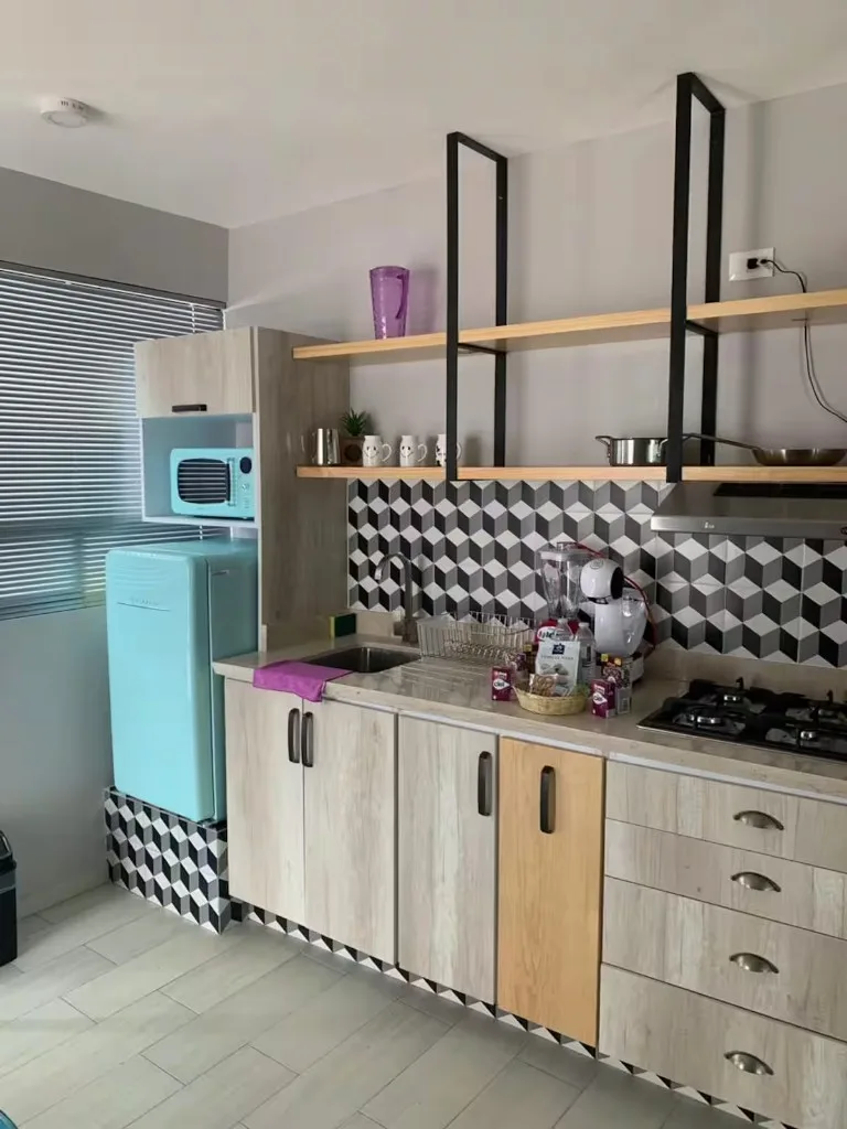 Cocina equipada de Suite Terraza en Suites 509, Pachuca: refrigerador retro, microondas, estufa y backsplash geométrico