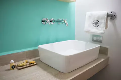 Amenidades de baño en Suite Terraza Suites 509, Pachuca: lavabo moderno, jabón, shampoo y toallas de marca Suites 509