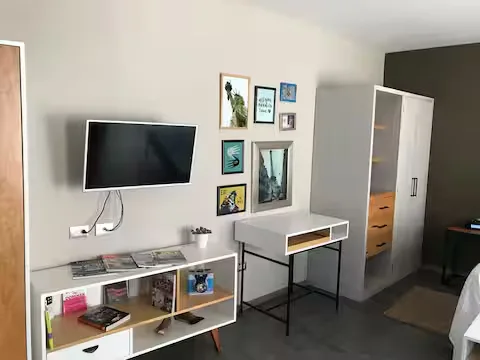 TV, escritorio y clóset en Suite Terraza Suites 509, Pachuca — loft equipado para descanso y trabajo remoto