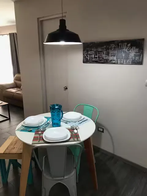 Comedor en Suite Terraza Suites 509, Pachuca: mesa redonda para tres, estilo industrial y cocina equipada al fondo
